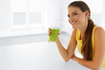 Wall Mural - Healthy Lifestyle. Closeup Of Beautiful Smiling Woman Drinking Green Detox Vegetable Juice. Healthy Diet And Eating. Vegetarian Food. Drink Smoothie. Health Care And Beauty Concept.