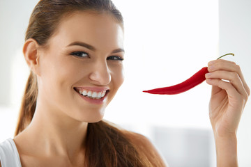 Wall Mural - Healthy Food. Close-up Of Beautiful Young Smiling Woman Holding Red Hot Chili Pepper. Healthy Lifestyle, Diet And Eating Concept.