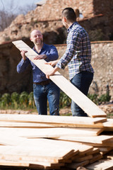 Wall Mural - Two builders carrying over plane