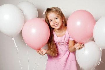 Wall Mural - Happy girl with a gift box in the form of heart and white and pink balloons 