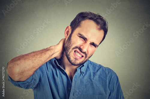 Cuadros en Lienzo stressed, unhappy young handsome man with bad neck pain