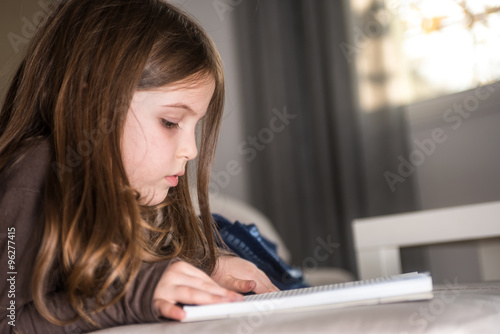 Cuadros en Lienzo Early education - little girl reading a book