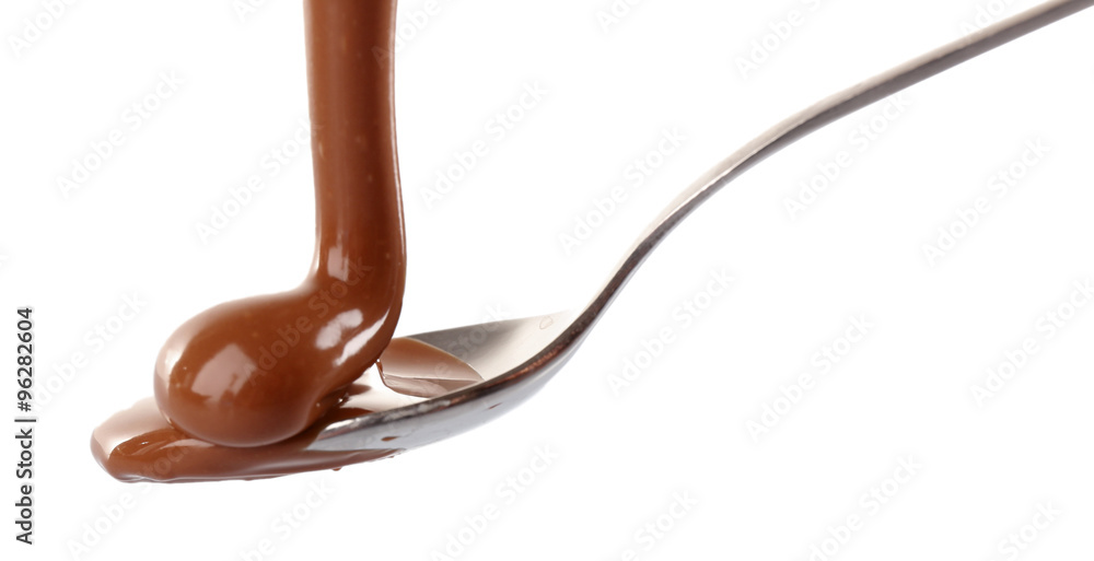 Melted milky brown chocolate pouring from a spoon, isolated on white