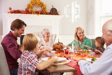 Family With Grandparents Enjoying Thanksgiving Meal At Table