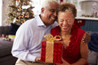 © Monkey Business - Senior Couple Exchanging Christmas Gifts At Home
