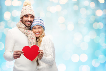 Canvas Print - smiling couple in winter clothes with red hearts