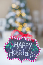 Winter Decorations With Happy Holidays Sign On Bokeh Background