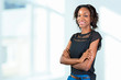 © fotofabrika - Happy young african woman standing with arms crossed