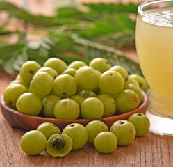 Poster - Indian gooseberry  in wooden bowl on a wooden floor.