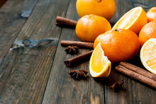 Tangerines, Oranges And Cinnamon Sticks On A Wooden Table