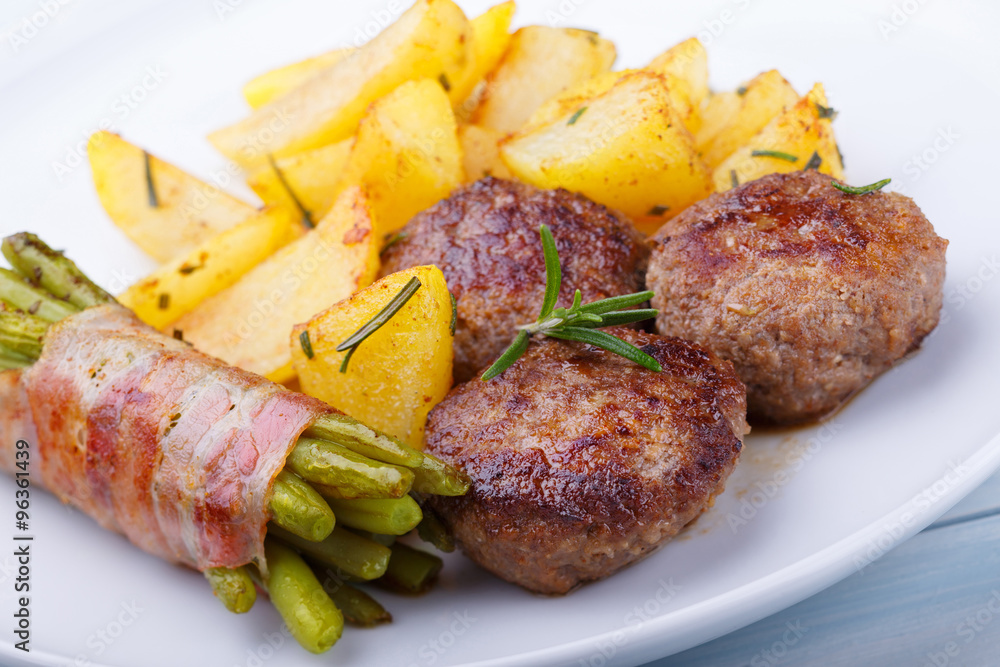 Stock-Foto „Frikadellen mit Bratkartoffeln und grünen Bohnen im ...