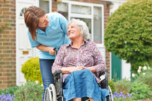 Carer With Senior Woman In Wheelchair