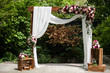 Wedding arch decorated with cloth and vivid flowers