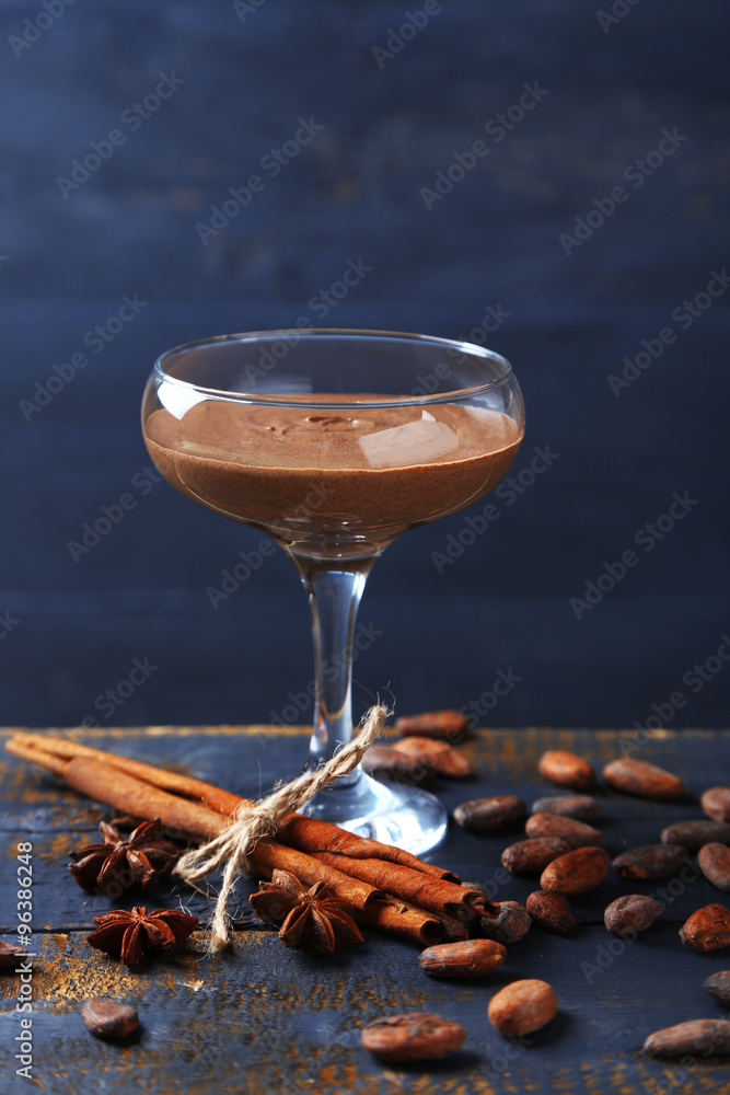 Chocolate dessert in glass on color wooden background