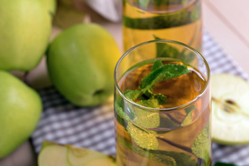 Canvas Print - Glasses of apple juice with fruits and fresh mint on table close up