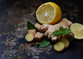 Ginger, lemon and mint on old dark background