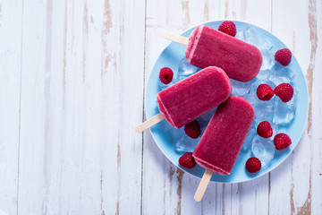 Homemade raspberry popsicles on plate