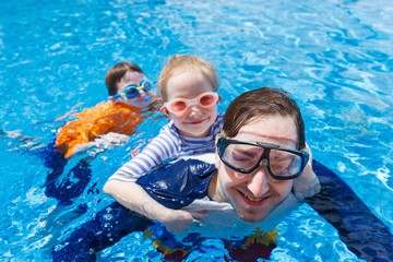 Canvas Print - Father and kids at swimming pool