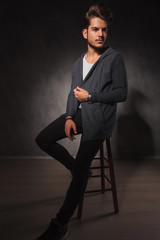 Wall Mural - male model posing in studio while arranging his jacket