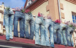 Funny picture of house facade decorated with group of blue jeans used as flower pots