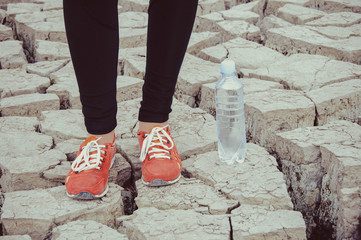 Wall Mural - sport, fitness, people and lifestyle concept - red sneakers on girl legs on the desert background