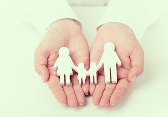 Wall Mural - Female hands holding toy family, closeup