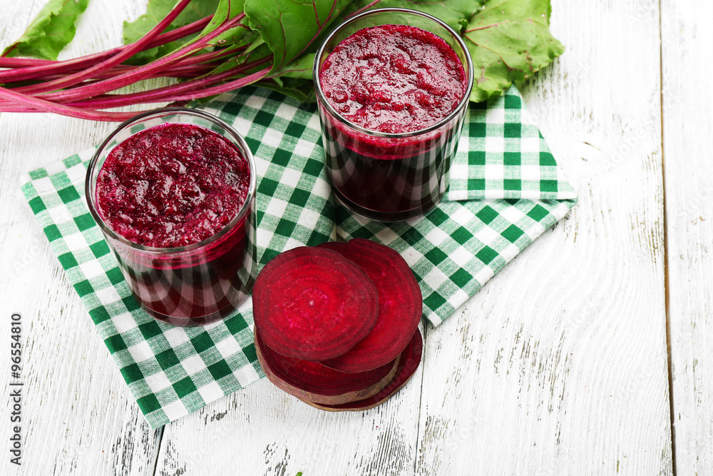 Glasses of beet juice with vegetables on table close up