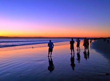 People Photographing The Sunset Along A Beach Seashore