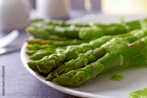 Fototapeta na szkło Fresh asparagus dish in green sauce on the table, close up