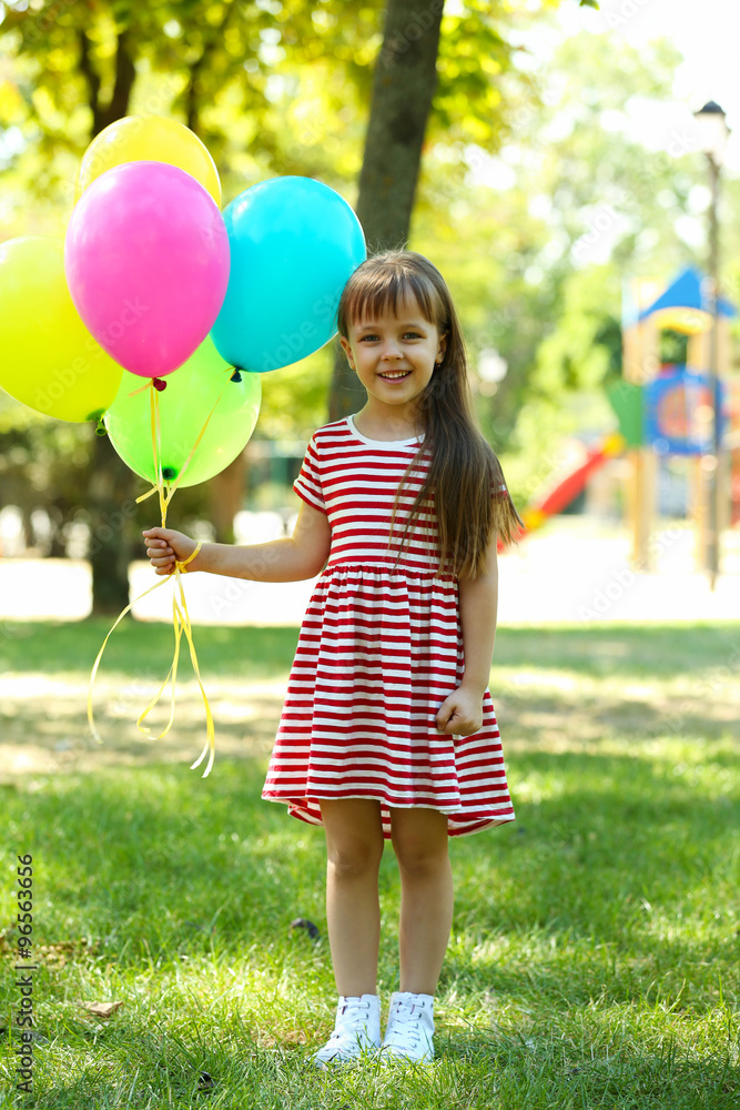Little girl with balloons in the park