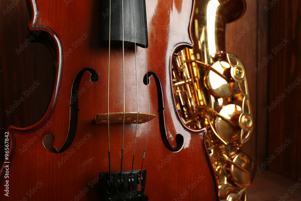 Close up view on musical instruments: saxophone, violin in wooden box