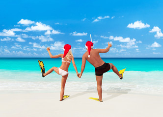 Canvas Print - Positive couple in Santa hats go diving on tropical beach