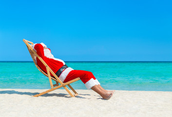 Poster - Christmas Santa Claus resting on sunlounger at ocean sandy tropical beach