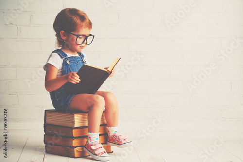 Dekoracja na wymiar  dziecko-dziewczynka-w-okularach-czyta-ksiazke