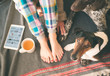 © Laszlo - Woman legs and two dogs lying on bed, tea and tablet on her side. Cute terrier and German pointer looking at camera.