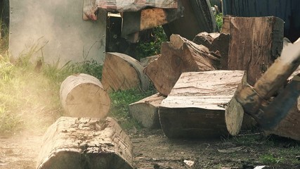 Wall Mural - Slow motion footage of lumberman cutting firewood logs with axe, man splitting wood to fit the fireplace