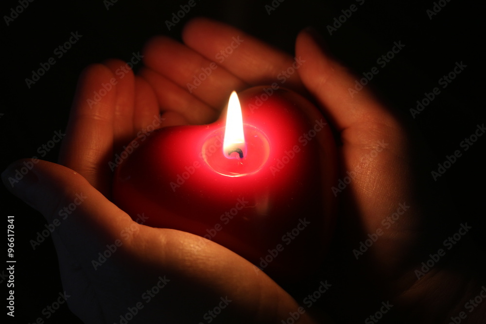 Herzkerze in den Händen Stock Photo