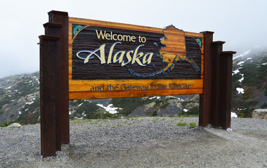 welcome to alaska sign on the canadian / usa border near skagway,