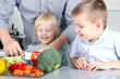 © Saklakova - Smiling cute daughter and son  cooking  a  dinner. Little children