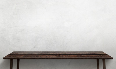 Modern wooden table with legs and free space. Cracked white wall texture in background.