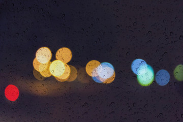 Wall Mural - Soft romantic colour bokeh light background with water or rain drop on mirror glass plate window