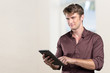 © fotofabrika - Smiling young man using tablet computer