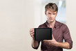 © fotofabrika - Smiling young man using tablet computer