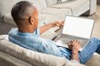 © WavebreakMediaMicro - Over shoulder view of casual man using laptop