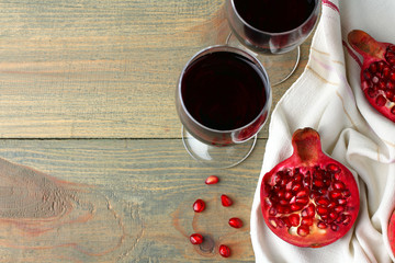 Wall Mural - juicy pomegranate on the fabric and the glasses of wine on wooden background