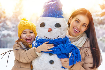 Wall Mural - Mother and child girl on a winter walk