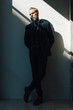 © SFIO CRACHO - Stylish bearded man wearing trendy suit and stands against the wall. Vertical