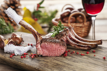 Wall Mural - hirschkarree scharf angebraten auf rustikalem küchenbrett mit einem glas wein im hintergrund