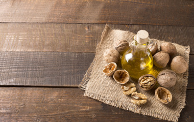 Wall Mural - top view of walnut oil and nuts on wooden table