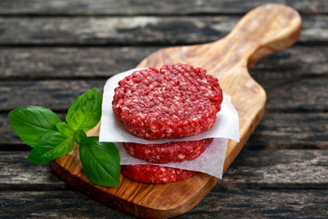 Home HandMade Minced Beef burgers on cutting board. old wooden table